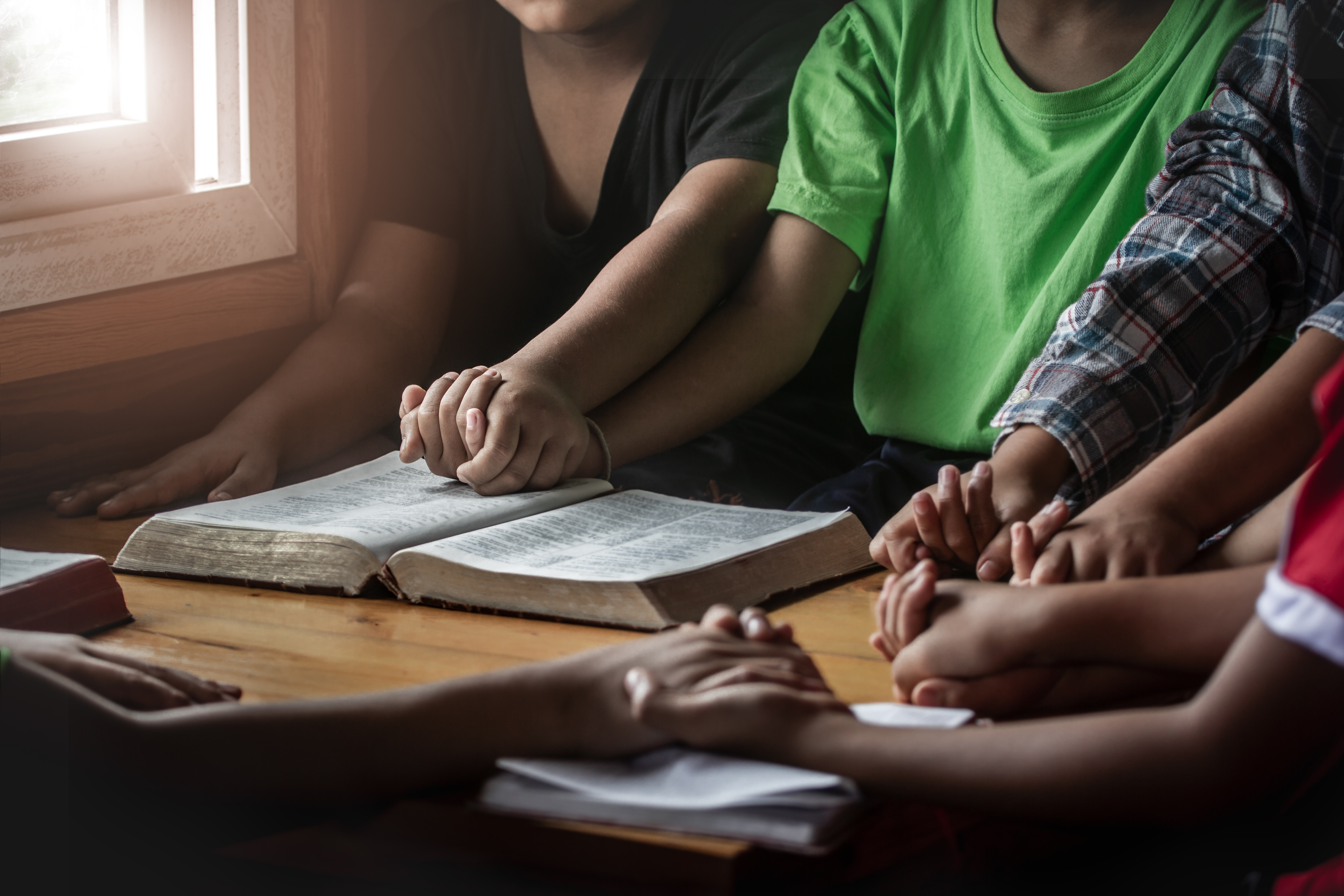 people holding hands around table