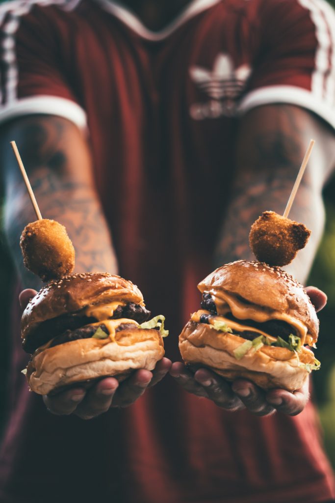 man holding two veggie burgers