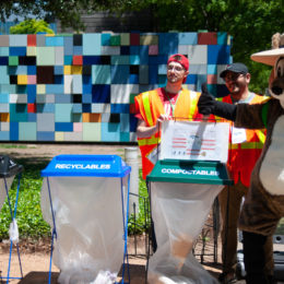 mascot and volunteer with trash bins