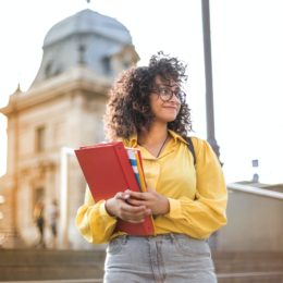 woman-in-yellow-jacket-holding-red-book