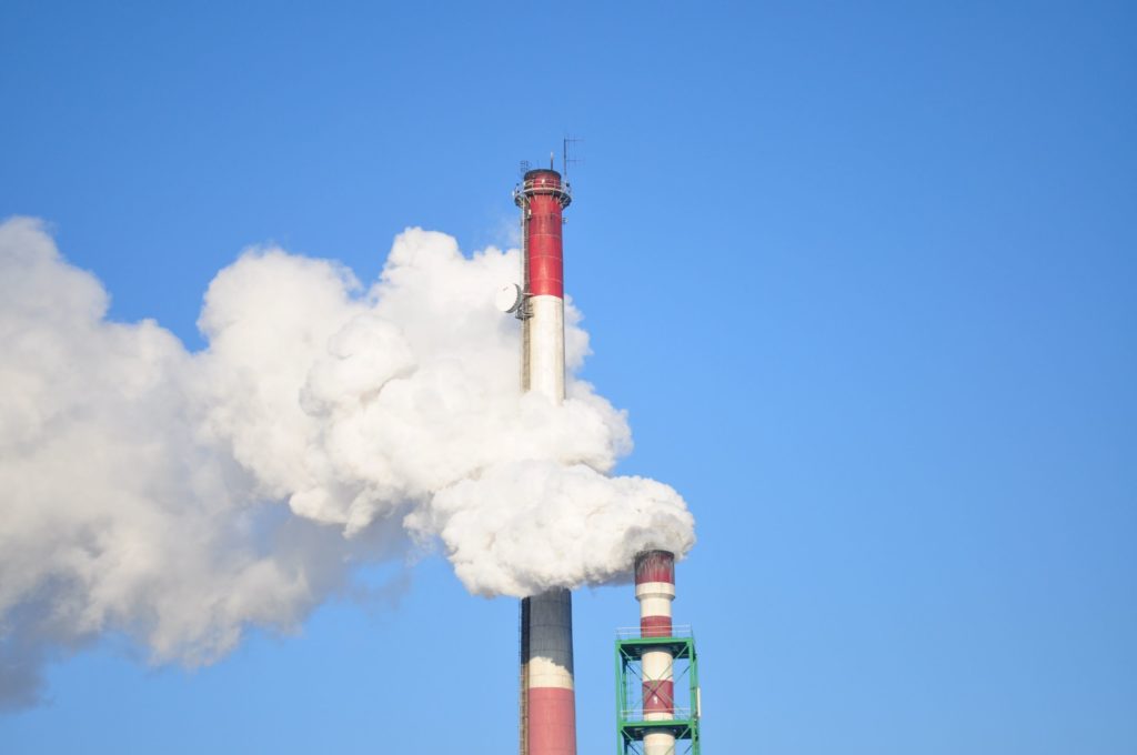 A power plant smokestack with billowing steam