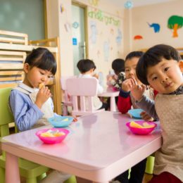 3 Preschool students eating lunch at a pink table