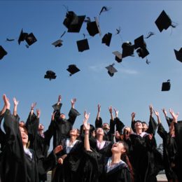 Group of people at a graduation ceremony throwing their caps into the air