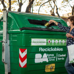 Person throwing can into recycling bin
