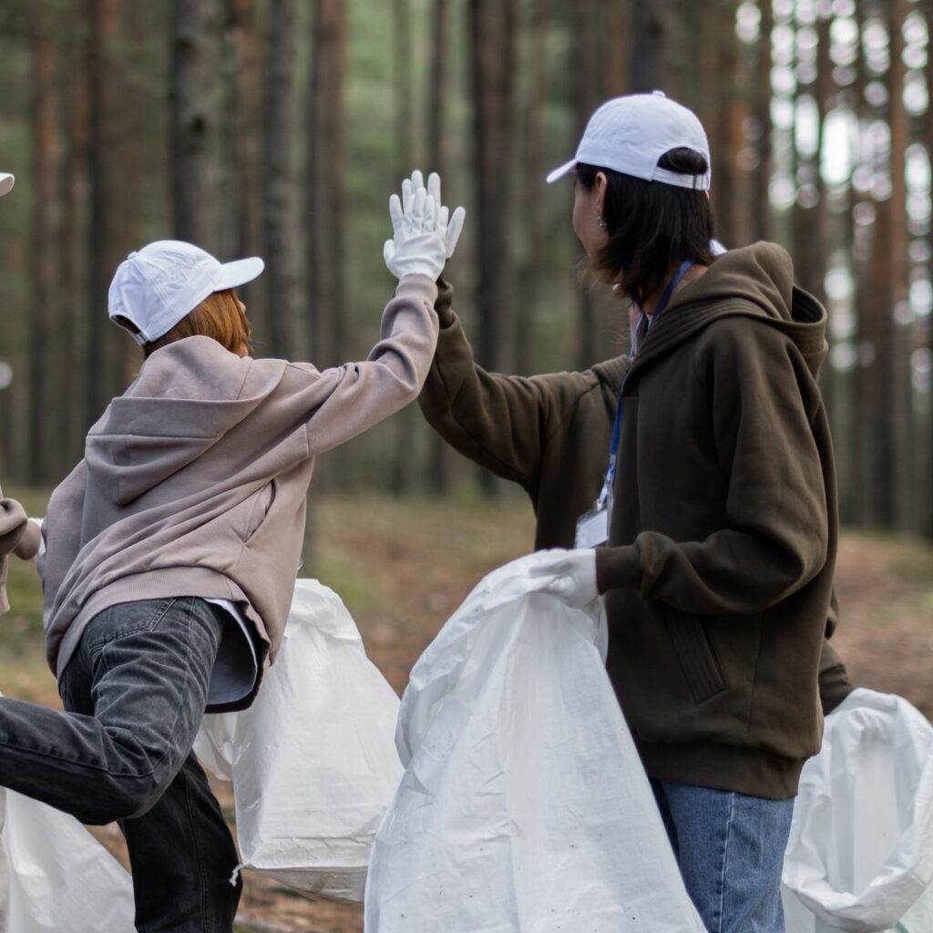 Two men high-fiving while participating in a cleanup.
