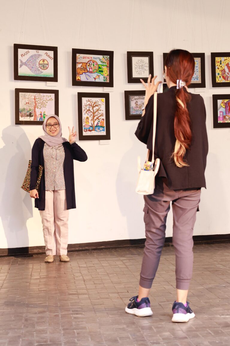 Visitors pose in front of the artworks inspired by indigenous art forms