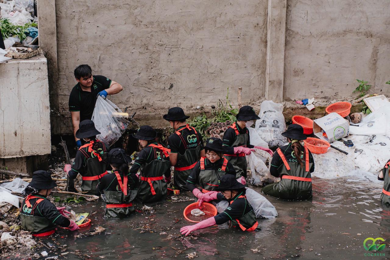 GoGreen youth volunteers in the canals of Ho Chi Minh City removing plastic waste