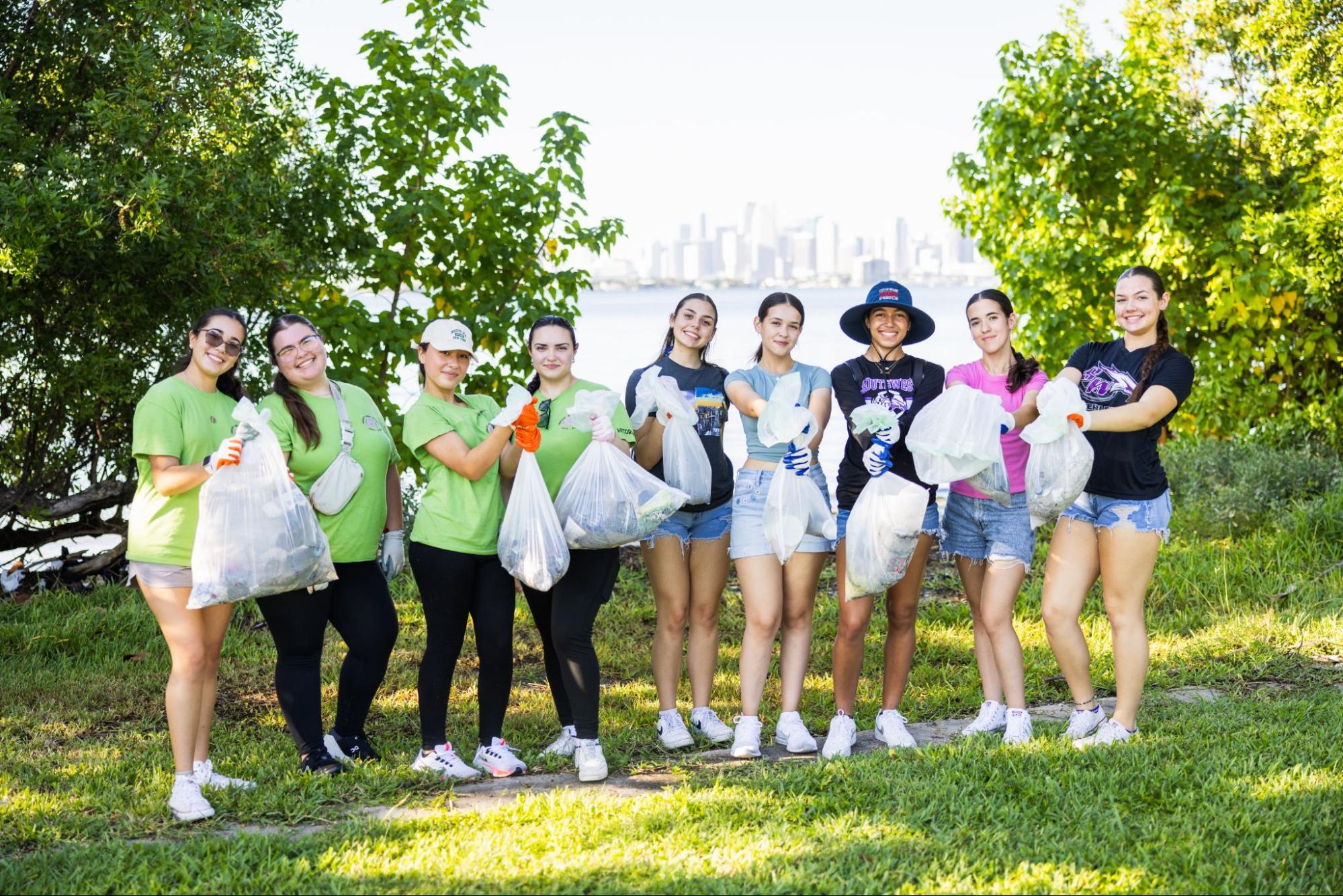 Volunteers posing with trash with Miami in background
