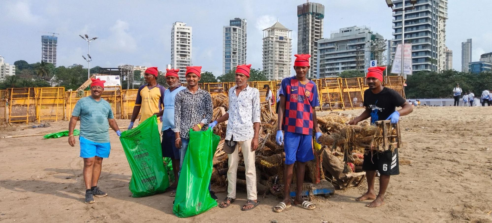 Volunteer pose holding green bags of trash