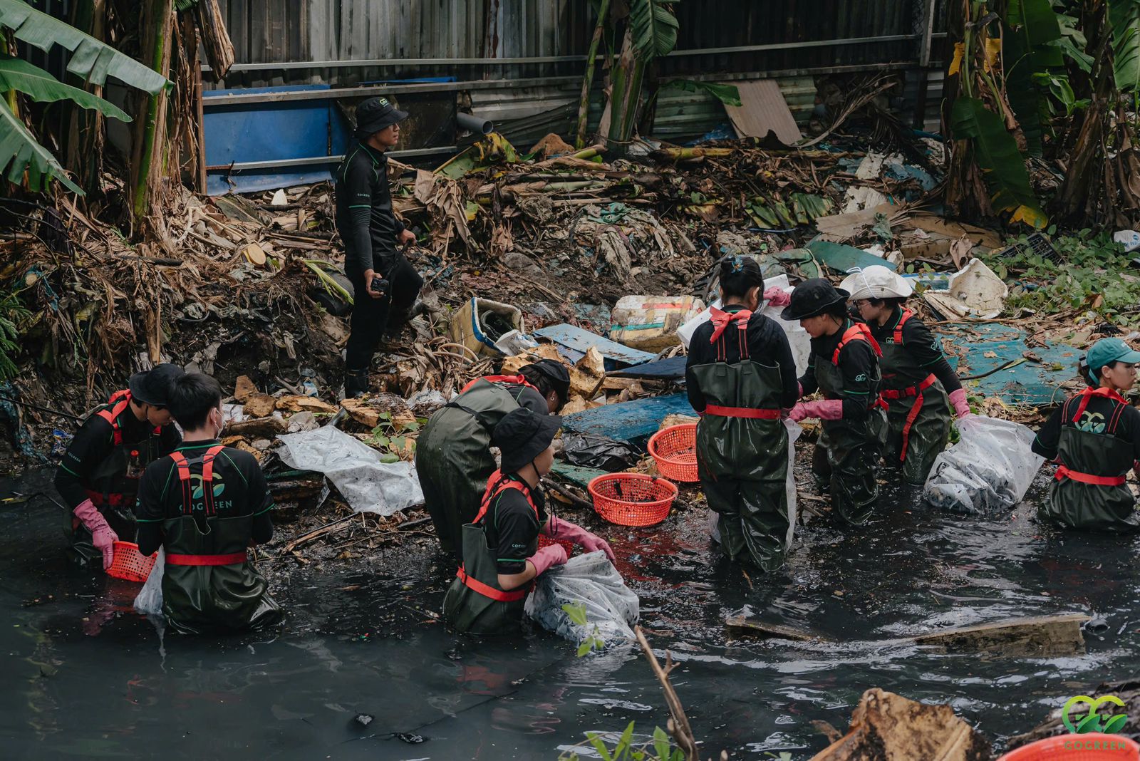 Volunteers waist deep in the foul-smelling canals removing trash