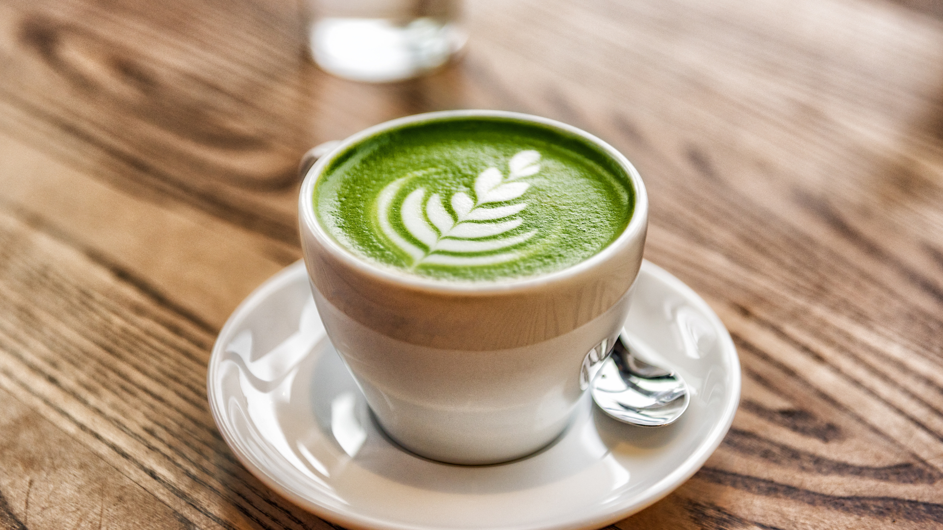 Small cup of matcha with a leaf.