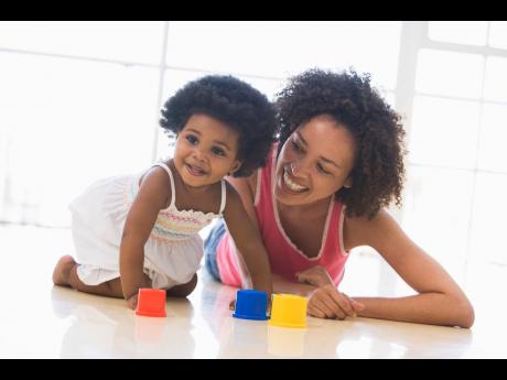 Photo of a mother and child playing with plastic toys
