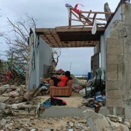 Person in a chair in a destroyed home.