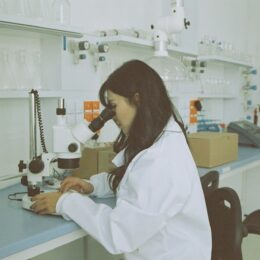 Woman in a labcoat at a microscope