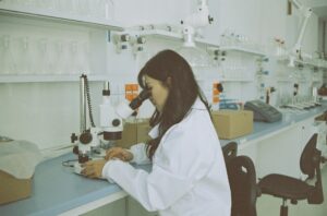 Woman in a labcoat at a microscope
