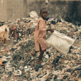 Child picking up plastics in a landfill