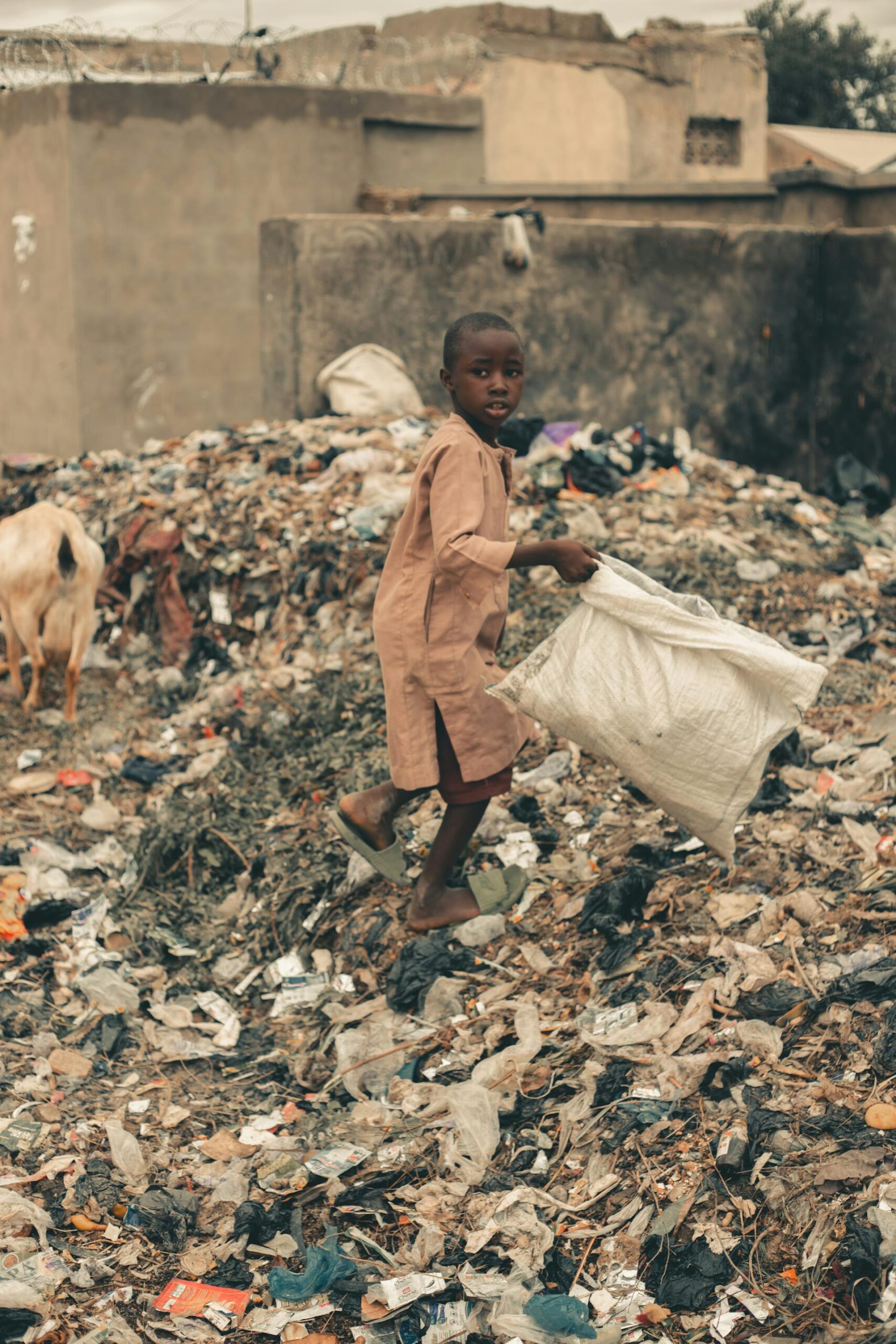 Child picking up plastics in a landfill