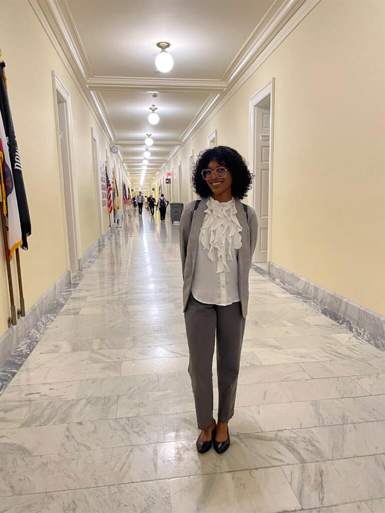 Amina standing in the hall between meetings