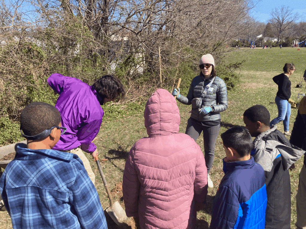 A teacher explains tree planting methods to the students.