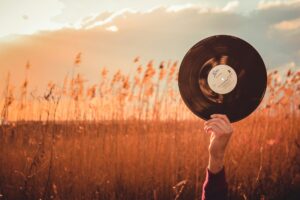 Person holding a vinyl record in a field