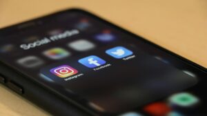 Instagram, Facebook, Twitter icons on a phone
