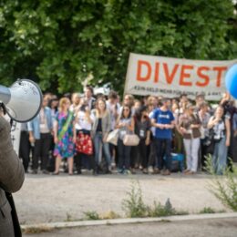 People protesting with a sign to divest