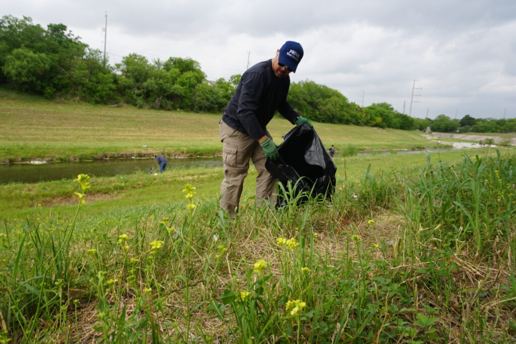 Great Global Cleanup volunteer picking up trash near a river
