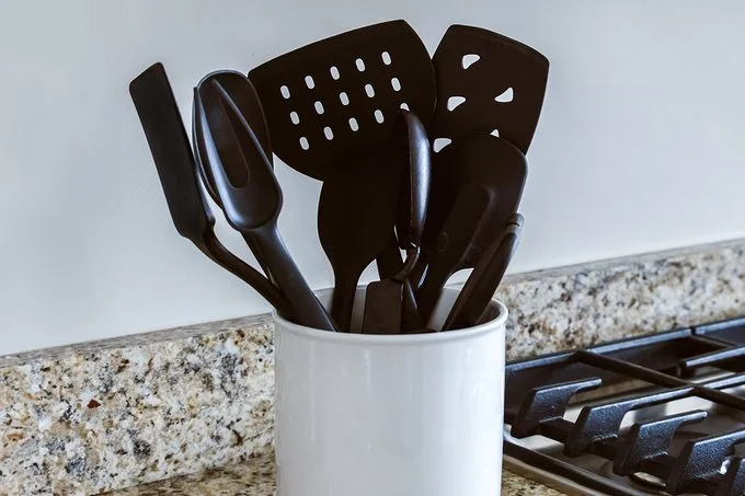 Black plastic utensils in a holder
