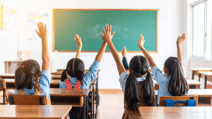 Children raising hands in a classroom