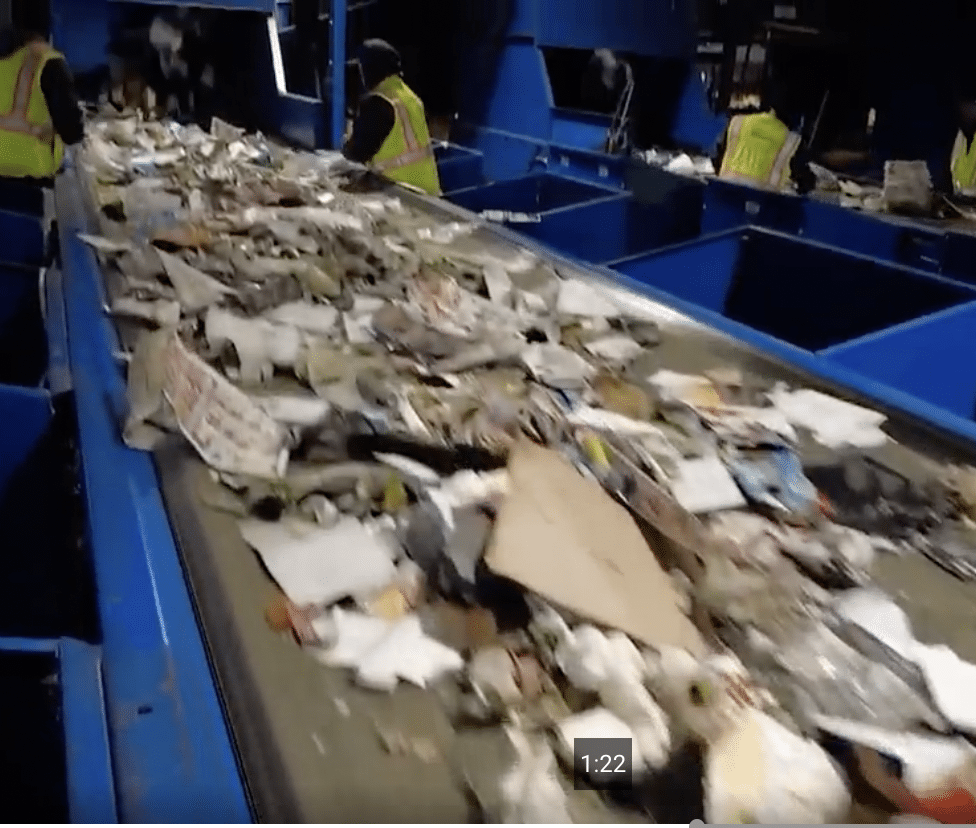 Garbage on a recylcing conveyer belt including plastic waste