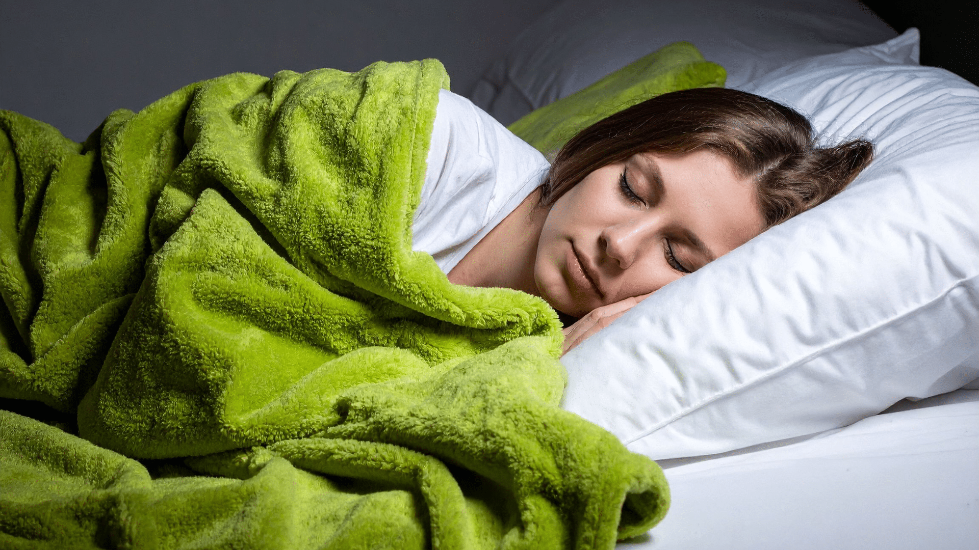 Woman sleeping under a green blanket