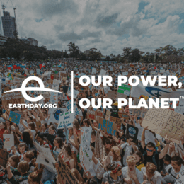 Earth Day celebration with crowd and the Earth Day logo plus the text