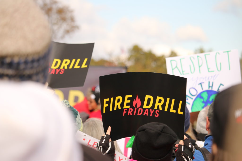 person holding fire drill fridays sign