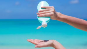 person applying sunscreen to hand